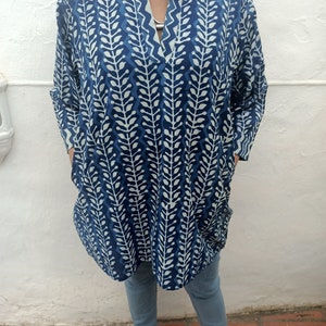 Op de afbeelding: Een blauwe tuniek met een wit patroon, een V-hals en lange mouwen. De tuniek heeft een losse pasvorm en is gemaakt van een lichtgewicht stof.