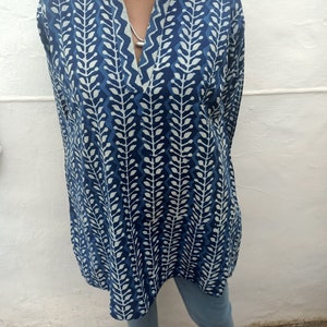 Op de afbeelding: Een tuniek met lange mouwen met een blauw en wit bladmotief. De tuniek heeft een V-hals en een losse pasvorm.