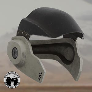 Puede incluir: Un casco gris y negro con visera. El casco tiene un diseño circular en el lateral y una serie de pequeños agujeros en la parte inferior. El casco está hecho de un material texturizado y tiene un aspecto desgastado.