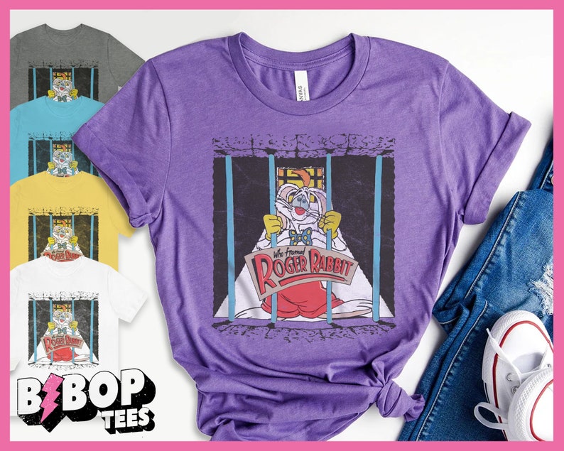 K&ouml;nnte beinhalten: Lilafarbenes T-Shirt mit einem Aufdruck von Roger Rabbit in einer Gef&auml;ngniszelle. Der Text auf dem Aufdruck lautet "We framed Roger Rabbit".