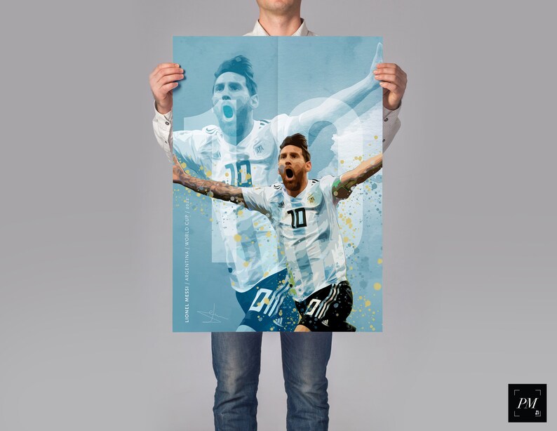 May include: A blue and white watercolor-style poster featuring a soccer player in a white jersey with the number 10 on it. The player is celebrating a goal with his arms raised in the air. The poster has the text "Lionel Messi / World Cup 2022" at the bottom.