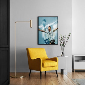 May include: A framed poster of a soccer player in a white jersey with the number 10 on it, celebrating a goal. The poster is hanging on a white wall above a yellow armchair in a living room.