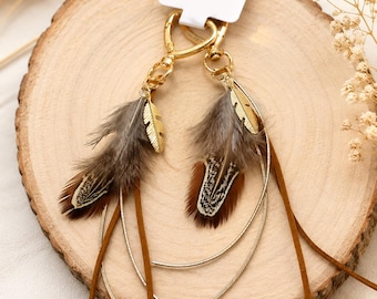 May include: A pair of gold-toned metal keychains featuring brown and grey patterned feathers, thin gold-toned curved metal accents, and brown suede-like leather cords, all attached to a gold-toned lobster clasp with a white rectangular display tag.