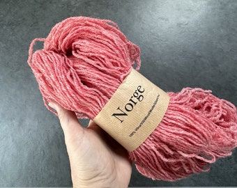 Puede incluir: Un ovillo de lana rosa con una etiqueta marrón que dice "Norge 100% Villans Wool/Wool Villans".