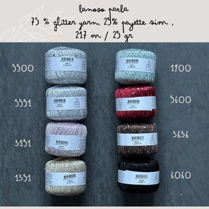 Op de afbeelding: Acht bollen garen in verschillende kleuren, waaronder zilver, roze, rood, bruin, zwart en beige. Elke bol heeft een etiket met de tekst "lanoso parla 75% glitter yarn, 25% payette sim, 217 m / 25 gr" en een nummer.