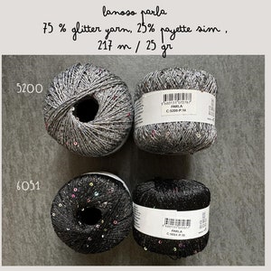 Op de afbeelding: Twee bollen garen, een grijs en een zwart, met zilveren glitter en pailletten. Het garen is gelabeld "lanoso parla 75% glittergaren, 25% pailletten sim, 217 m / 25 gr".