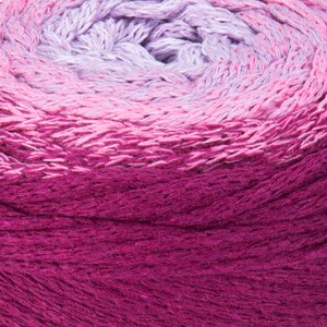 Puede incluir: Primer plano de una madeja de hilo con un degradado de colores morado, rosa y magenta.