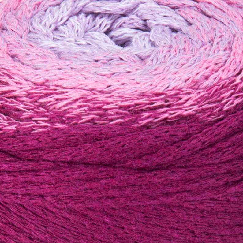 Puede incluir: Primer plano de una madeja de hilo con un degradado de colores morado, rosa y magenta.