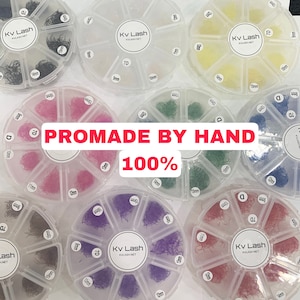 May include: A set of 10 clear plastic containers with individual compartments, each containing a different color of eyelash extensions. The containers are labeled with the brand name "Kv Lash" and the text "Promade by Hand 100%".