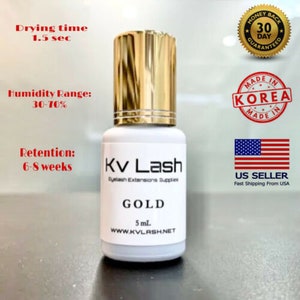 May include: A 5 ml bottle of gold eyelash extension adhesive with a white label that says "Kv Lash Eyelash Extensions Supplies GOLD 5 ml. WWW.KVLASH.NET". The bottle has a gold cap and a drying time of 1.5 seconds. The humidity range is 30-70% and the retention is 6-8 weeks.