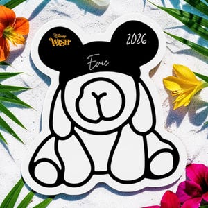 May include: A white and black die-cut sticker shaped like a bear with Mickey Mouse ears. The sticker features the text "Disney Wish" and the name "Evie" with the year "2026". The sticker is surrounded by flowers and palm leaves.