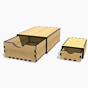 Peut inclure: Deux boîtes de rangement en bois avec tiroirs coulissants. La plus grande boîte est ouverte, révélant l'intérieur. Les boîtes sont brun clair avec des bordures noires et un motif pointillé décoratif sur les bords. Les tiroirs ont une découpe incurvée pour une ouverture facile.