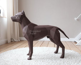 May include: A brown papercraft model of a pit bull dog standing on a white rug. The dog is in a standing pose with its head turned to the side. The text "Polygonal Paper" is visible on the dog's side.