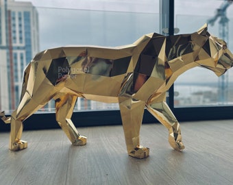 May include: A gold-colored, geometric, origami-style tiger sculpture. The sculpture is made of paper and has a shiny, metallic finish.