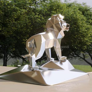 Op de afbeelding: Een zilverkleurig, metalen leeuwbeeldhouwwerk met een geometrisch low-poly ontwerp. De leeuw staat op een bijpassende hoekige basis. Het oppervlak is sterk reflecterend en toont highlights en schaduwen. De tekst "Polygonal Paper" is zichtbaar.