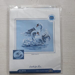 May include: A cross stitch kit featuring a design of two swans on a light blue background. The kit includes the text "SWAN FIDELITY" and "Create for Fun". The dimensions of the finished piece are 40 x 35 cm.