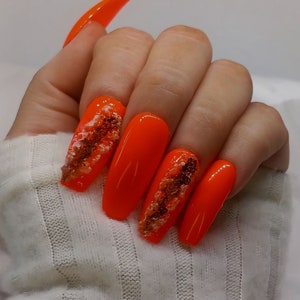 Luxury handmade one of a kind press on nail kit. Long ballerina shaped neon orange nails with 3D geode effect accent nails.