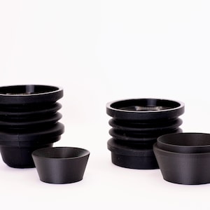 May include: Three black silicone molds for making candles. The molds are different sizes and have a ridged design.