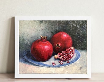 May include: A still life painting of three red pomegranates on a blue and white patterned plate. The pomegranates are arranged in a cluster, with one cut open to reveal the red seeds inside.