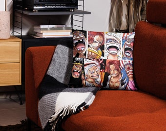 May include: A red, black, and white throw pillow with a collage of cartoon faces. The pillow is on a red couch with a black and white throw blanket.