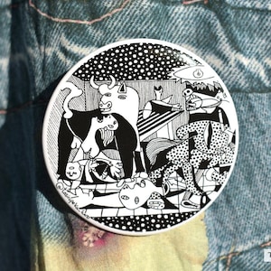 May include: Black and white ceramic coaster featuring a stylised illustration of a bull, a woman, and a man. The design is reminiscent of a famous painting.