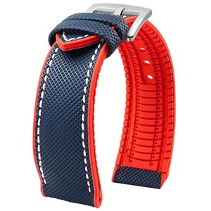 Puede incluir: Una correa de reloj azul y roja con detalles de costura blanca. La correa est&aacute; hecha de un material de goma texturizado.