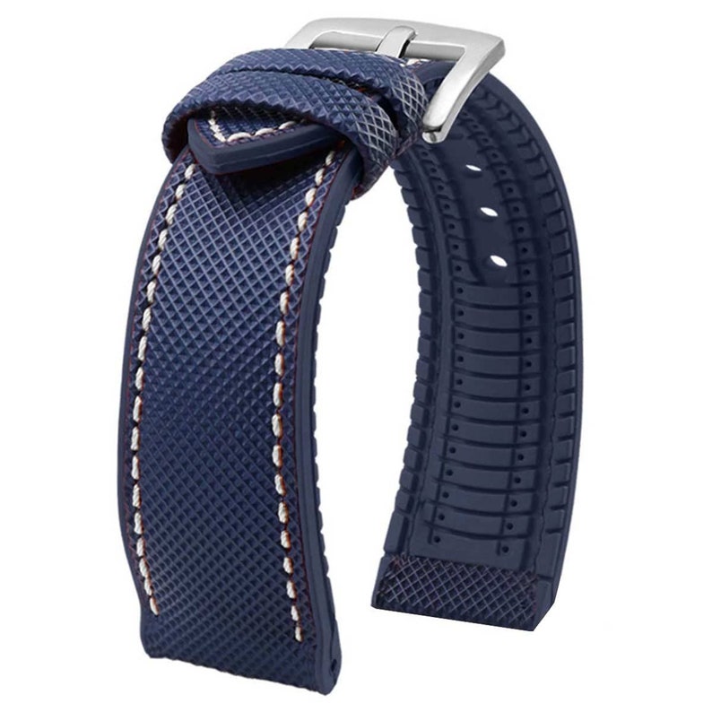 Puede incluir: Una correa de reloj azul con una superficie texturizada y costuras blancas. La correa tiene un cierre de hebilla y est&aacute; hecha de un material duradero.