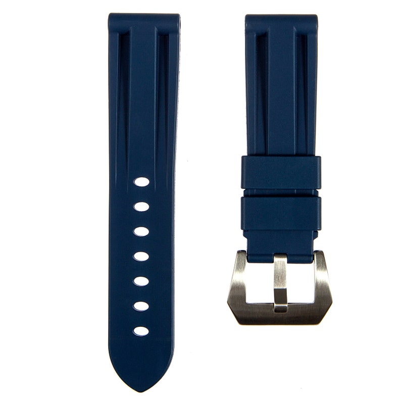 May include: A dark blue rubber watch strap with a silver buckle. The strap has a textured design and is designed for a watch with a 20mm lug width.