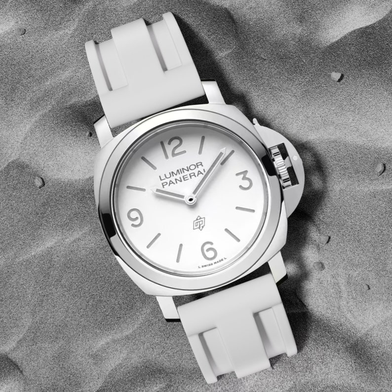 May include: A white wristwatch with a white rubber band. The watch face is white with black markings and the text "Luminor Panerai" printed on it.