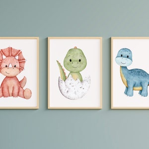 May include: Three framed watercolor illustrations of cute cartoon dinosaurs. The first dinosaur is red with three horns and is sitting down. The second dinosaur is green and is hatching from an egg. The third dinosaur is blue and is standing up.