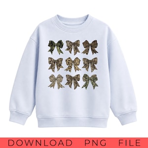May include: A light blue long-sleeve sweatshirt featuring a grid of nine decorative bows on the front. Each bow displays a unique pattern, including various shades of green camouflage, brown animal prints, and textured earth-toned designs.