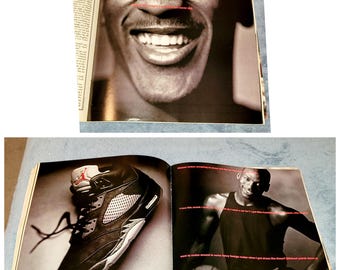 Może przedstawiać: Rozwinięcie magazynu przedstawiające czarne i szare buty Nike Air Jordan oraz koszykarza w białej koszulce bez rękawów i czarnych spodenkach. Tekst na stronie brzmi: "Uwielbiam ten model. Potrzebuję go. Potrzebuję samochodu? Mam buty do koszykówki. Kto potrzebuje samochodu?"