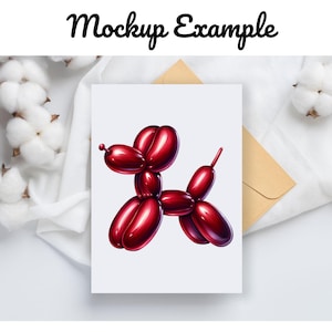 May include: A red balloon animal shaped like a dog on a white card. The card is on a white surface with a brown envelope and white cotton balls.