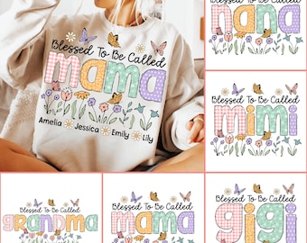 May include: A white sweatshirt with a floral design and the text "Blessed To Be Called mama" in colorful patchwork letters. The names Amelia, Jessica, Emily, and Lily are written below the main text.