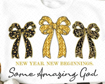 Peut inclure: Sweat-shirt blanc avec trois nœuds décoratifs. Les nœuds présentent des motifs dorés à paillettes et léopard noir. Le texte "NEW YEAR. NEW BEGINNINGS. Some Amazing God" est imprimé en dessous.