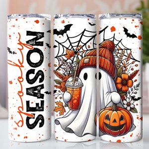 May include: White tumbler with a ghost holding a pumpkin and a cup of coffee. The tumbler has a black and orange design with the words "Spooky Season" on the front.