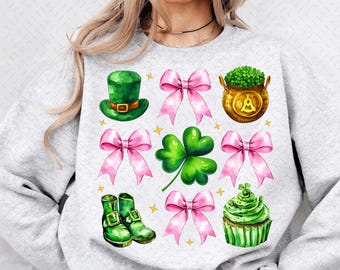 May include: A gray sweatshirt with a festive St. Patrick's Day design. The design features a green leprechaun hat, a pot of gold, shamrocks, pink bows, and green boots.