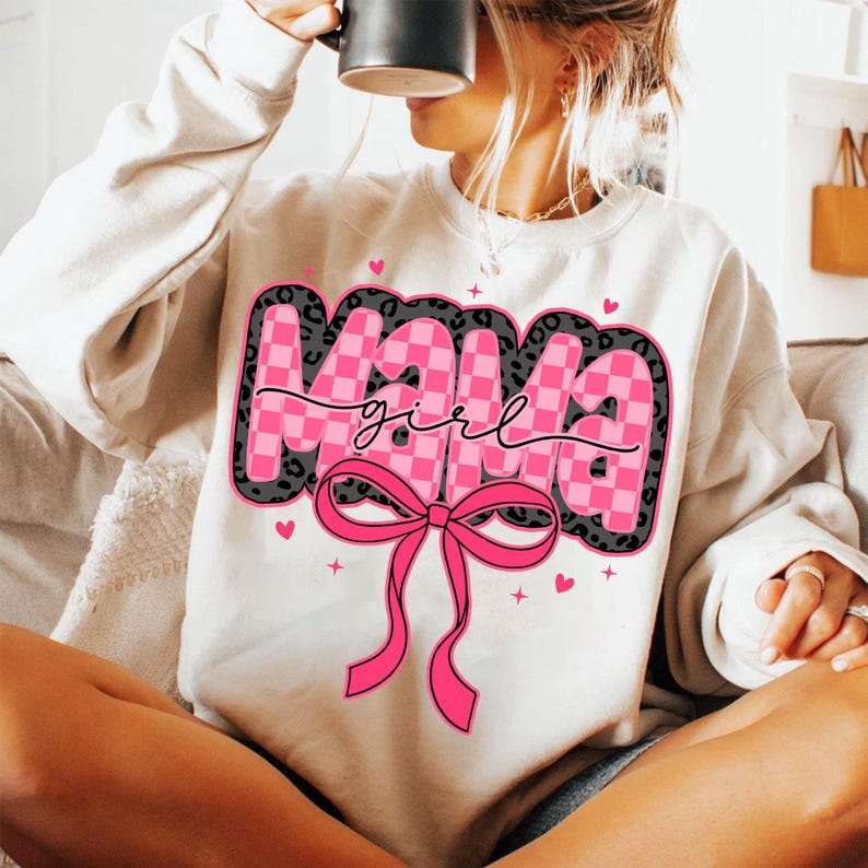 May include: White sweatshirt with a pink and black graphic that says "Mama girl" with a pink bow.