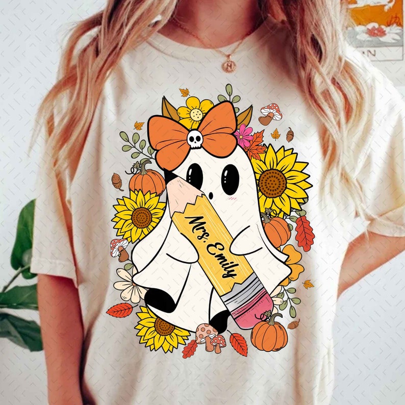 May include: A white ghost with a pink bow and a yellow pencil that says "Mrs. Emily" is surrounded by sunflowers, fall leaves, and mushrooms.