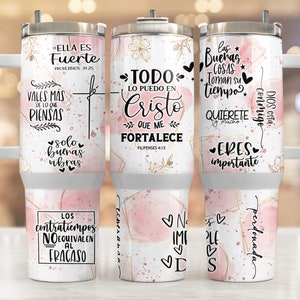 Puede incluir: Tres vasos de acero inoxidable con diseños en rosa y dorado y frases inspiradoras. Las frases incluyen "Ella es Fuerte", "Todo lo puedo en Cristo que me fortalece", y "Las buenas cosas toman su tiempo".