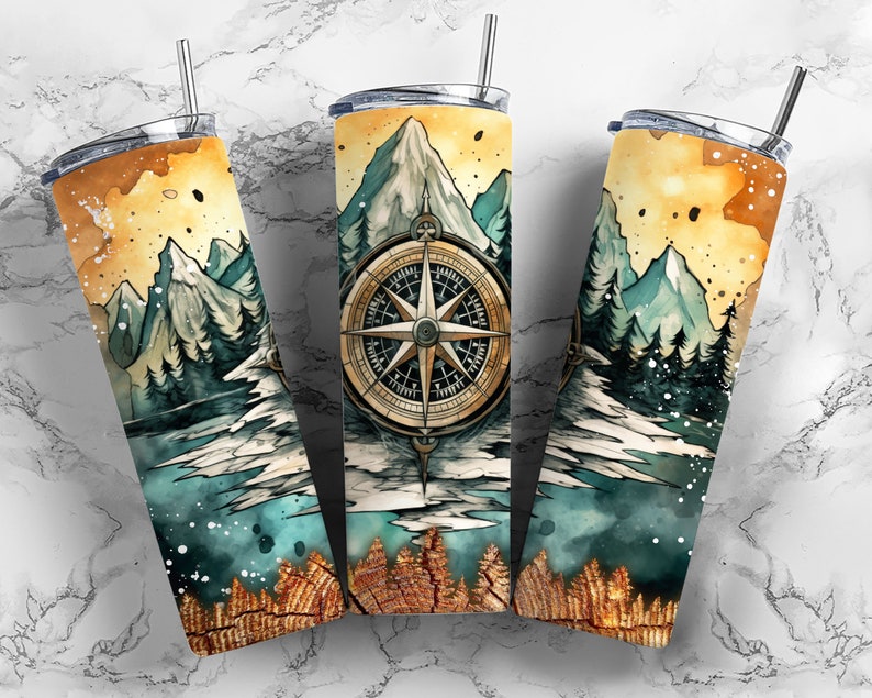 Peut inclure: Un gobelet en acier inoxydable avec un motif aquarelle de montagnes, une boussole et une for&ecirc;t. L'arri&egrave;re-plan est jaune clair avec des accents bleus et verts.