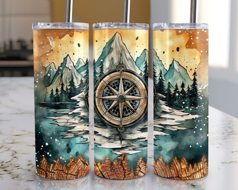 Peut inclure: Trois gobelets en acier inoxydable avec un motif aquarelle de montagnes, une boussole et une for&ecirc;t. Les gobelets ont un couvercle et une paille dor&eacute;s.