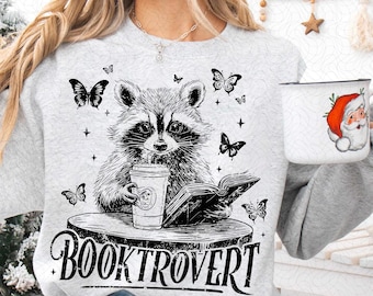 Booktrovert PNG, Amante de los libros divertidos PNG, Mapache leyendo PNG, Librero de moda PNG, Regalo para amantes de los libros PNG Sublimación