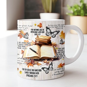 May include: White ceramic mug with a colorful design featuring butterflies, fall leaves, and bible verses. The verses include "In him was life and was the light of all men John 1:4", "For nothing will be impossible with God Luke 1:37", "They rep "Believe I Lord Jesus you will be you and your h Act 16:", "E my hiding place y shield. I hope in your word Psalm 119:114", "All this through ives me strength pians 4:13", "For by grace you have been saved through faith Ephesians 2:8-9", and "For we walk by not by sight 2 Corinthians 5".