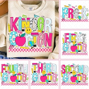 Puede incluir: Sudadera color crema con la palabra "Kindergarten" en letras de bloque coloridas. El diseño incluye una manzana rosa, un globo terráqueo, lápices y margaritas. Diseños adicionales muestran "Pre-K", "First Grade", "Second Grade", "Third Grade" y "Fourth Grade".