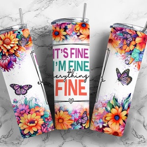 May include: Three stainless steel tumblers with a white background and colorful floral designs. The tumblers have a quote that reads "It's fine I'm fine everything fine" with a heart at the bottom.