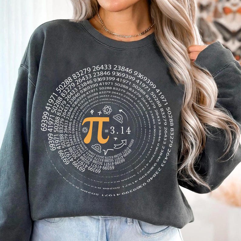 May include: A black sweatshirt with a white graphic of a spiral of numbers and the mathematical symbol pi with the equation pi = 3.14. The graphic also includes a protractor, a compass, and a right angle symbol.