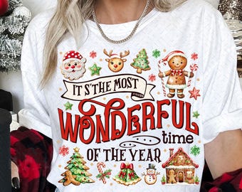 Könnte beinhalten: Weißes T-Shirt mit einem Weihnachtsmotiv mit Lebkuchenmännern, einem Rentier, einem Schneemann und einem Weihnachtsbaum. Der Text auf dem Shirt lautet "Es ist die schönste Zeit des Jahres."