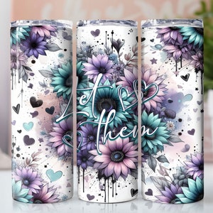 May include: White tumbler with a floral design featuring blue and purple flowers. The text "Let Them" is printed on the tumbler.