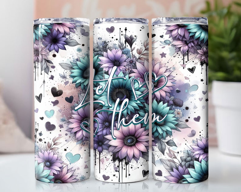 May include: White tumbler with a floral design featuring blue and purple flowers. The text "Let Them" is printed on the tumbler.